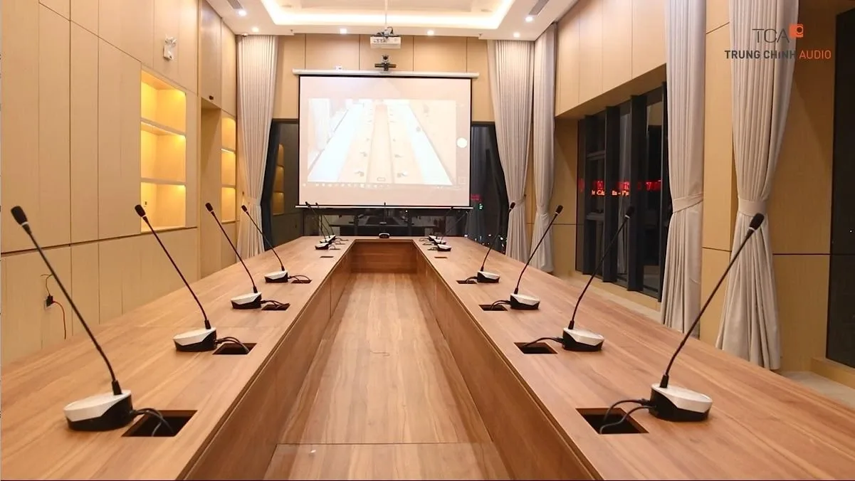 Wired conference microphones installed around a boardroom table